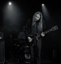 a black and white photo of a man playing a guitar