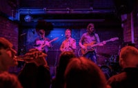 a group of people playing music in a dark room